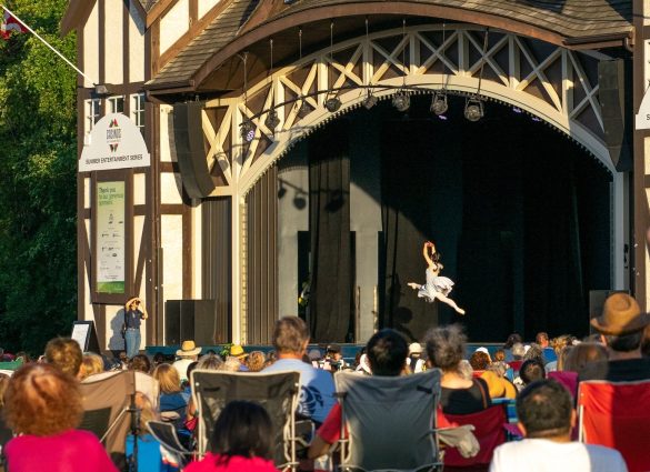 Teatro Lírico del Parque Assiniboine con gente disfrutando del espectáculo sobre la hierba y en sillas de jardín.