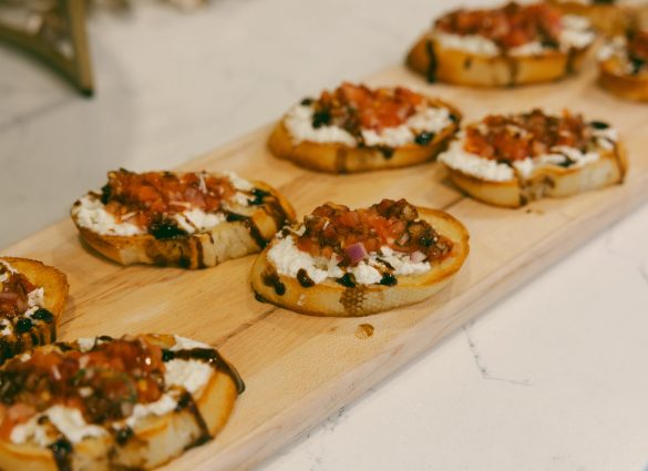 Un plateau en bois de bruschetta servi dans la salle à manger Commons Social Kitchen + Bar de l'hôtel Holiday Inn & Suites Winnipeg Downtown.