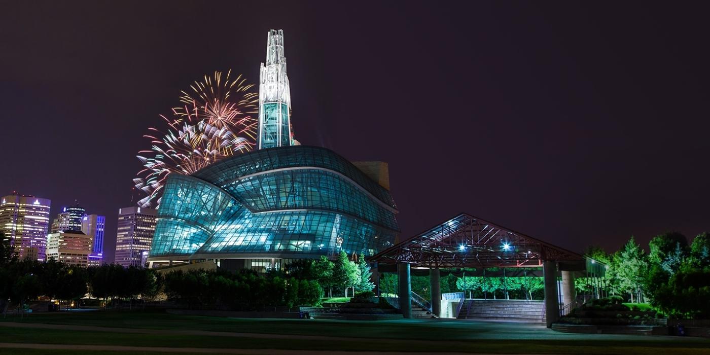 Fireworks behind Canadian Museum for Human Rights late in the evening to illuminate the sky.