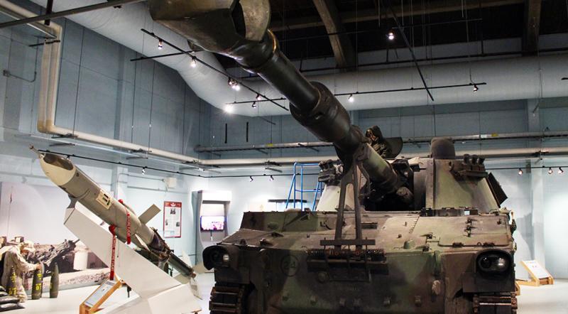 A rocket and a tank side by side, showcasing modern engineering marvels for space exploration and ground mobility.