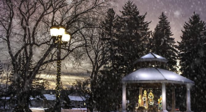 Pérgola cubierta de nieve justo después del atardecer, durante una suave nevada.