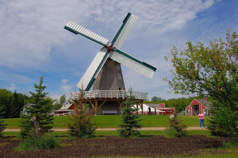 Steinbach windmill on a farm with surrounding barns, showcasing a classic rural scene in Manitoba.
