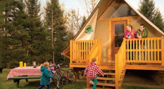 Niños corriendo hacia un Otentik mientras sus padres les saludan desde el porche, disfrutando de sus bebidas favoritas.