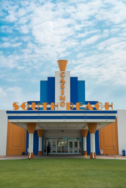 Exterior shot ng orange at blue art deco main entrance sa South Beach Casino.