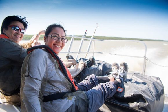 Two individuals relax with their feet up while boating, enjoying a leisurely fur-trade journey to their next destination.