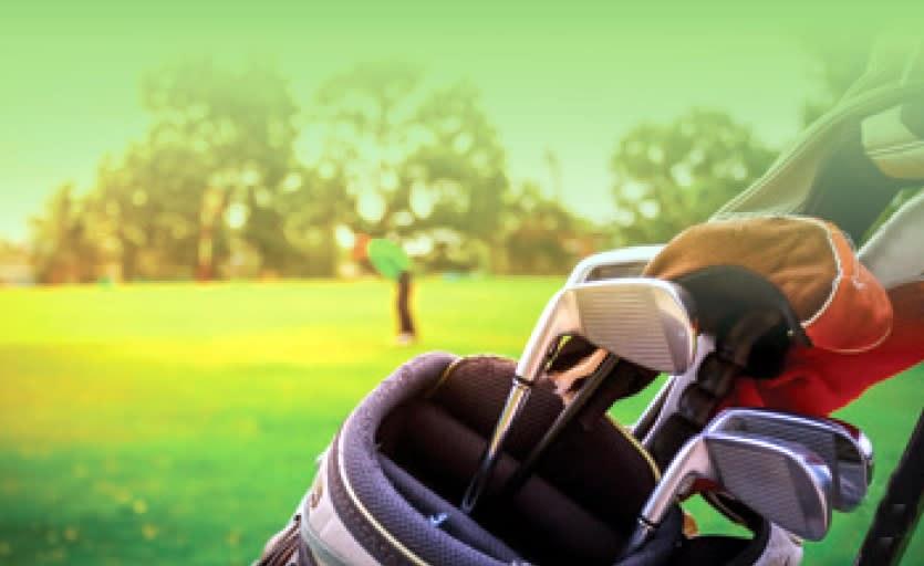 Golf bag with clubs: Ready for the greens, a golfer's essentials against the backdrop of the course in Manitoba.