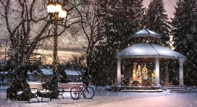 Illuminations de Noël dans un belvédère situé dans le parc, alors que la neige tombe au coucher du soleil.