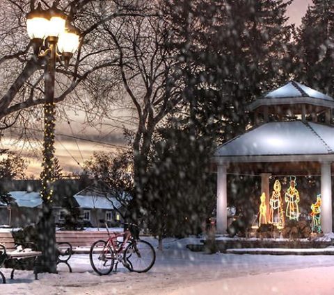Illuminations de Noël dans un belvédère situé dans le parc, alors que la neige tombe au coucher du soleil.