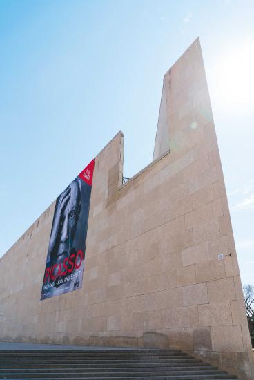 WAG architecture comes to a point with Picasso banner draped off its side, highlighting cultural richness in Manitoba.