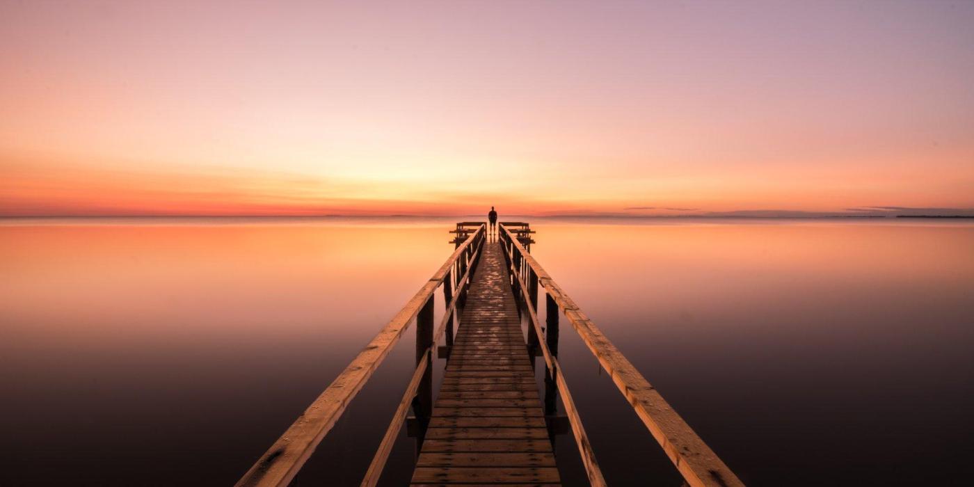 Nakatingin sa kahabaan ng isang Matlock dock sa Lake Winnipeg sa paglubog ng araw.