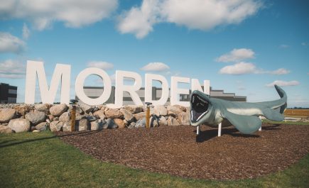 Mosasaurier-Attraktion und Schild am Straßenrand von Morden