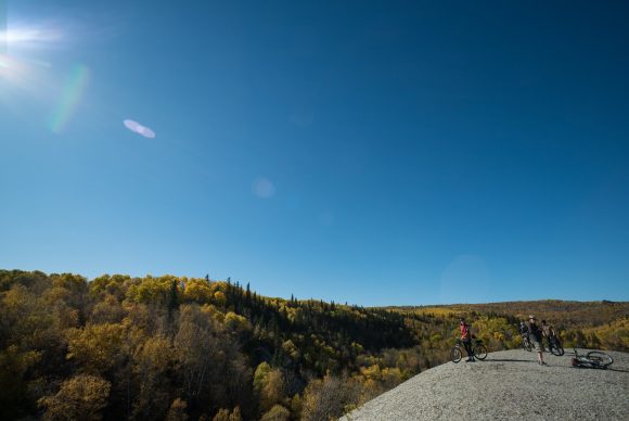 Ciclistas de montaña que se detienen en la cima de Bald Hill para contemplar las vistas en el Parque Nacional de Riding Mountain.