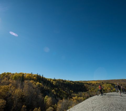 Mountain bikers stopping on top of Bald Hill to take in the view at Riding Mountain National Park.