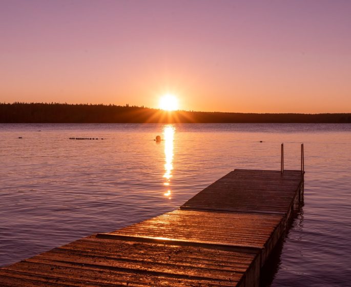 Sonnenuntergang am Ende eines Stegs in der Deep Bay im Riding Mountain National Park.