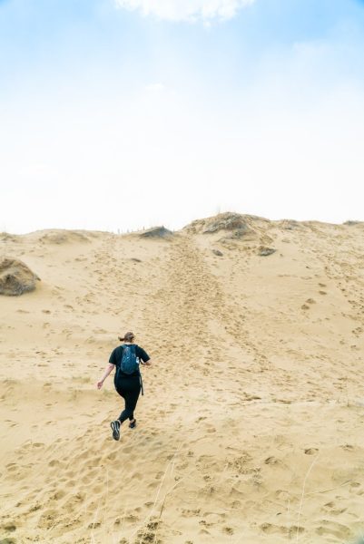 Una persona corre por las dunas de Spirit Sands en un día soleado.