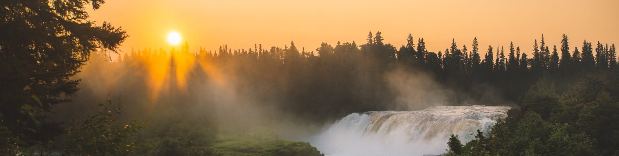 Umambon na tumataas sa ibabaw ng Pisew Falls sa paglubog ng araw.