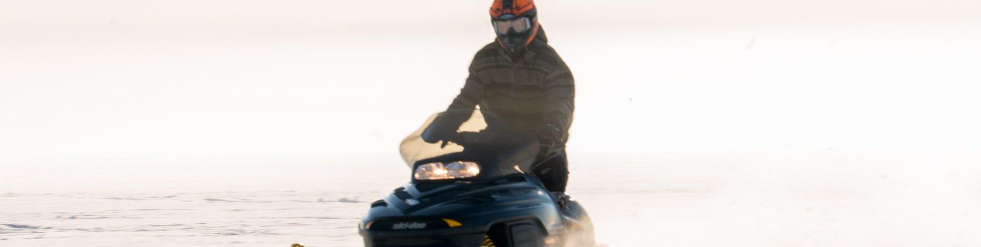 Moto de nieve cruzando un lago cubierto de nieve