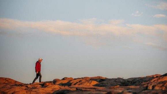 Una persona practica senderismo en una cresta rocosa de Flin Flon.