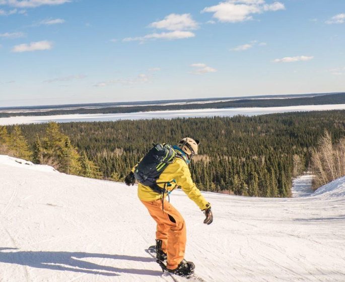 Snowboarder in yellow heading down a slope at Mystery Mountain Winter Park.