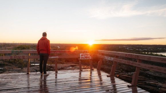 Una persona observa la puesta de sol desde un mirador en Flin Flon.
