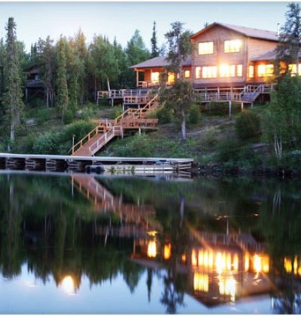 Cabaña de pesca en un acantilado reflejada en el lago al atardecer.