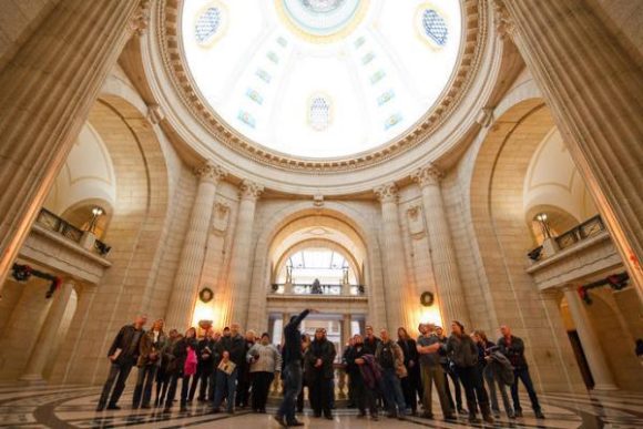 Un grupo de personas observa la cúpula de la Asamblea Legislativa de Manitoba durante la visita guiada del Código Hermético.