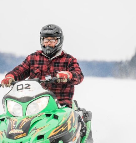 Eine Person beim Schneemobilfahren in der Nähe von Snow Lake, Manitoba
