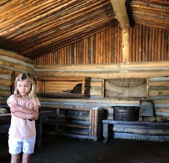 Niño de pie dentro de la casa de tepes