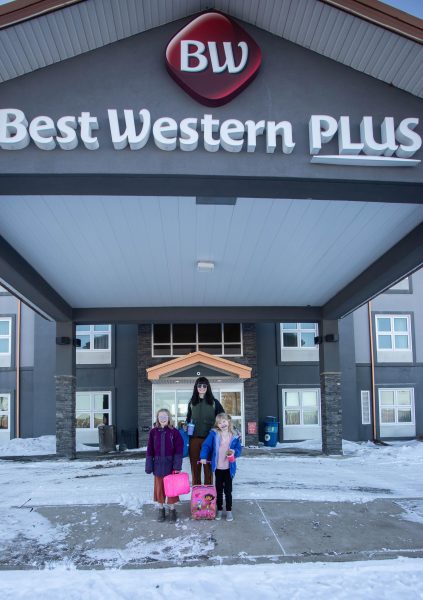 Exterior shot of a mom and two daughters sanding outside the Best Western Plus in Brandon.
