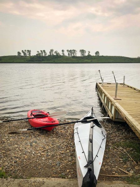 Two kayaks on the rocky shore of the Boissevain reservoir.