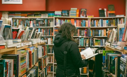 Une femme lit un livre dans l'allée de la librairie Whodunit ? à Winnipeg, Manitoba.