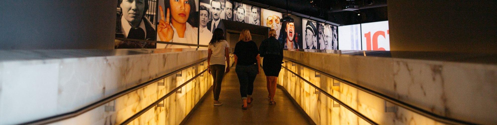 Tres mujeres suben por la pasarela de alabastro al siguiente piso del Museo Canadiense de Derechos Humanos.