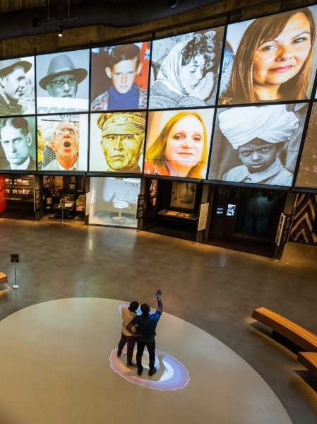 Dalawang tao na nakatingin sa mga larawang naka-project sa dingding sa Canadian Museum for Human Rights