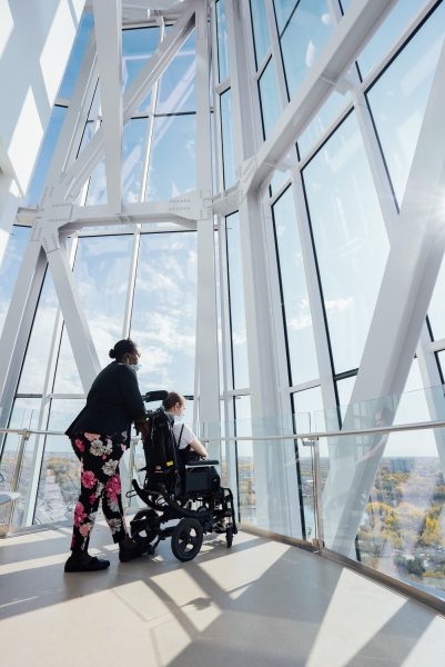 Dalawang tao, kabilang ang isa sa isang wheelchair na nakatingin sa labas ng Tower of Hope sa Canadian Museum for Human Rights