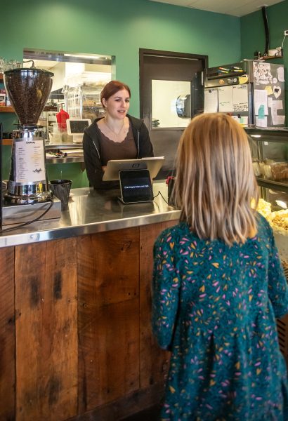 over the shoulder shot of one of the daughters ordering from the barista.