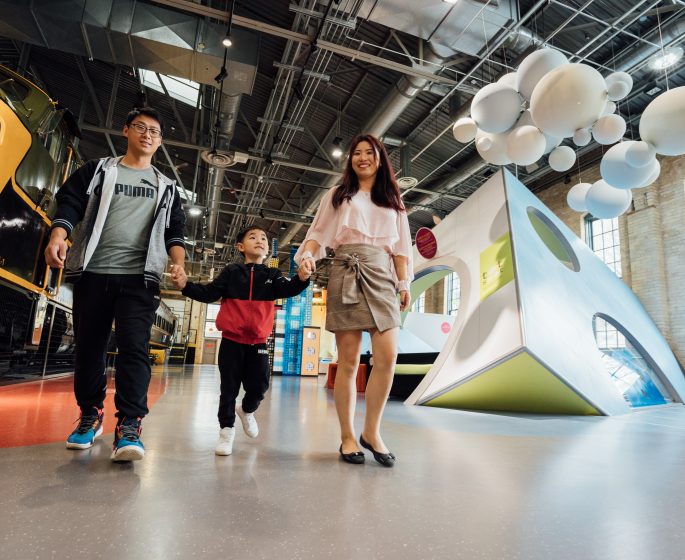 Couple walking through a museum with their child holding his hand in Manitoba ca