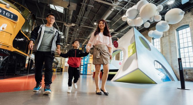 Couple se promenant dans un musée en tenant un enfant par la main, au Manitoba.