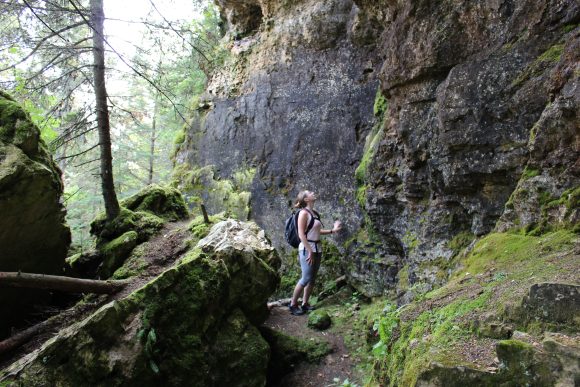 Woman looing up at the cliffs on a hiking trail in the Clearwater Lake caves