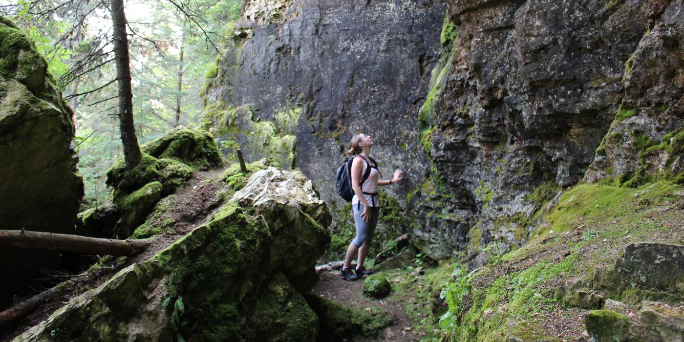 Babae na nakatanaw sa mga bangin sa isang hiking trail sa mga kuweba ng Clearwater Lake