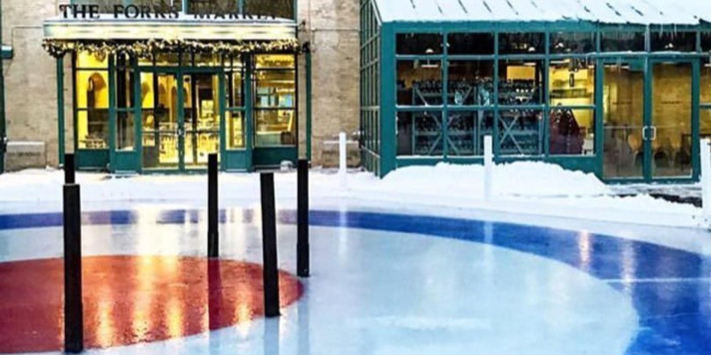 Hybrid Crokinole curling board set up outside of the Forks Market. Ice is patterned with blue, white and red circles.