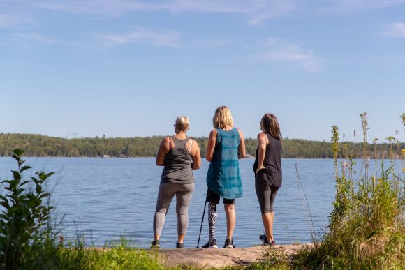 Drei Personen auf einem Granitfelsen blicken über den Falcon Lake.