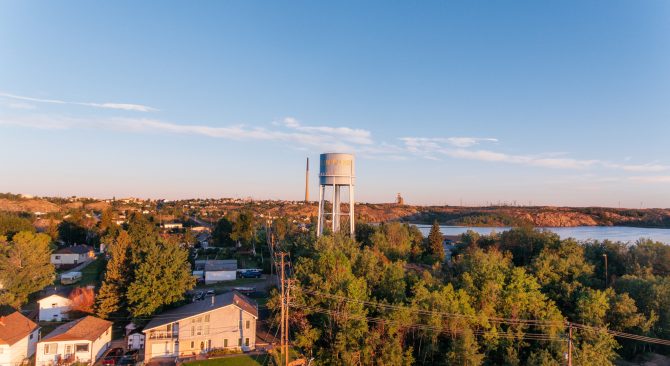 Drohnenaufnahme mit Blick auf die nördliche Stadt Flin Flon mit einem Wasserturm in der Ferne.