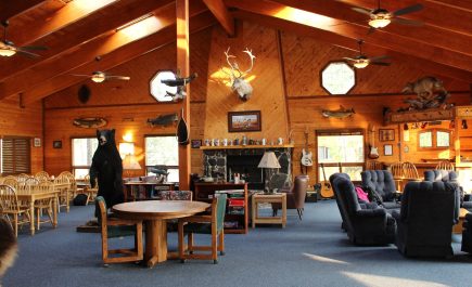 Interior del Gangler's Lodge con cabezas de ciervo montadas, peces y guitarras en las paredes de madera.