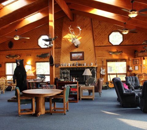 Interior del Gangler's Lodge con cabezas de ciervo montadas, peces y guitarras en las paredes de madera.