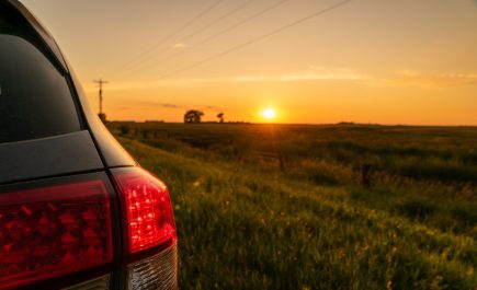 Tinatanaw ang mga ilaw sa likod ng kotse sa paglubog ng araw sa ibabaw ng bukid.