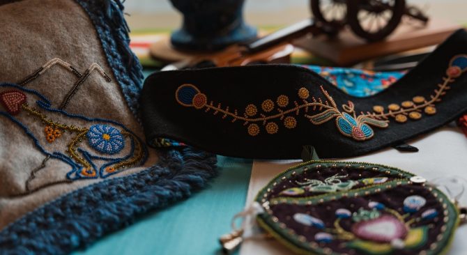 Des textiles et des accessoires finement brodés, qui mettent en valeur des motifs éclatants et un savoir-faire artisanal sur des surfaces colorées.