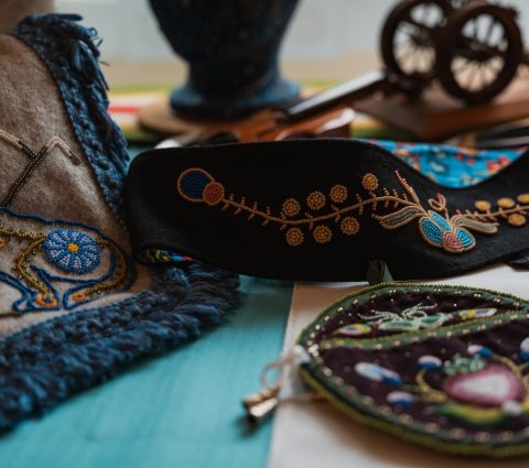 Des textiles et des accessoires finement brodés, qui mettent en valeur des motifs éclatants et un savoir-faire artisanal sur des surfaces colorées.