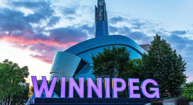 Cartel de Winnipeg frente al Museo Canadiense de Derechos Humanos al atardecer