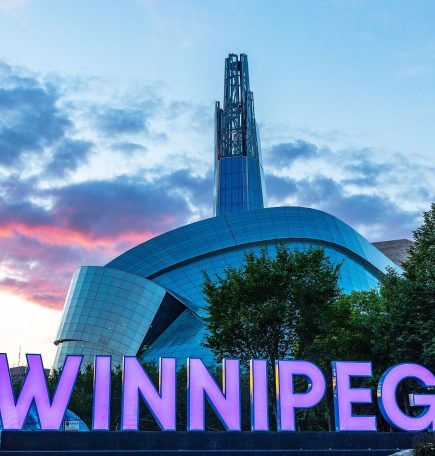 Cartel de Winnipeg frente al Museo Canadiense de Derechos Humanos al atardecer