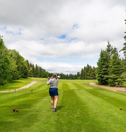 Mujer dando el primer golpe en el campo de golf de Clear Lake.